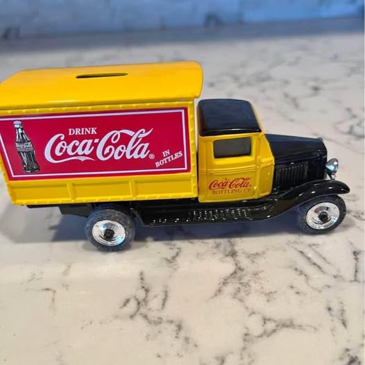 Yellow diecast delivery truck model with Coca-Cola Drink logo on side