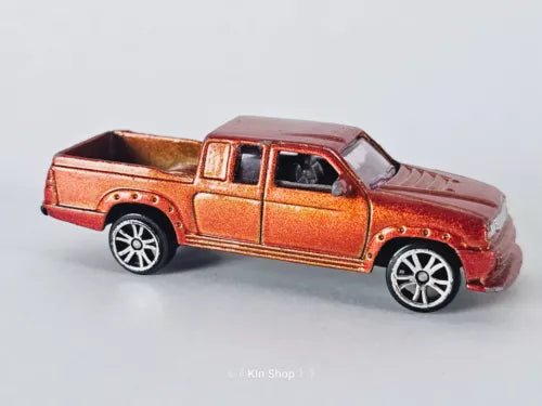 Orange diecast pickup truck with chrome grille, side view, black wheels