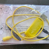 Yellow drone controller with attached cables and instruction sheet background