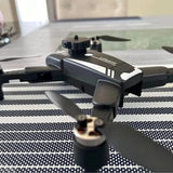 Compact quadcopter drone with camera, dark gray body and front prop guards