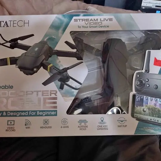 Quadcopter drone with four propellers, shown in retail packaging