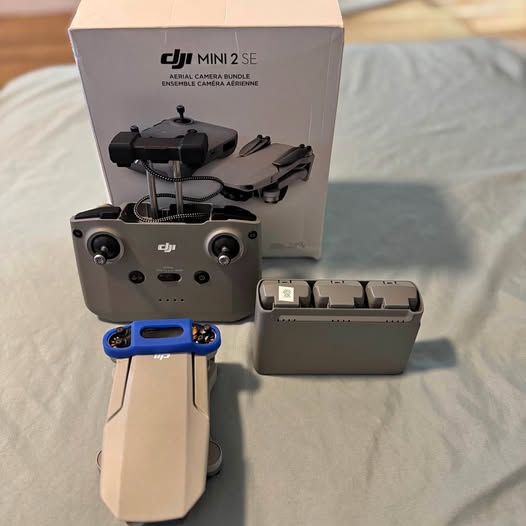 DJI Mini 2 SE drone with gray controller case and blue remote controls