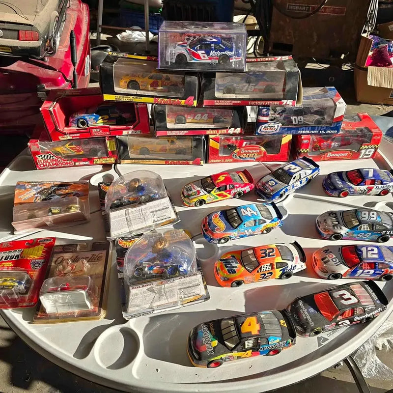 Diecast race car assortment in packaging, multi-color cars with numbers on display