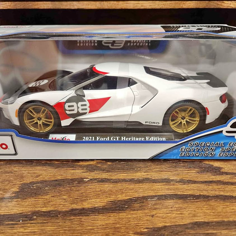 White diecast sports car with red/black racing stripes, gold wheels, rear spoiler
