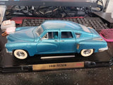 Light blue vintage diecast car model on black display stand with nameplate