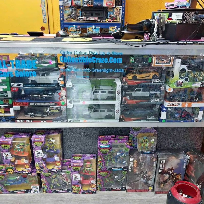 Assorted diecast car packages on retail display with trucks and cars