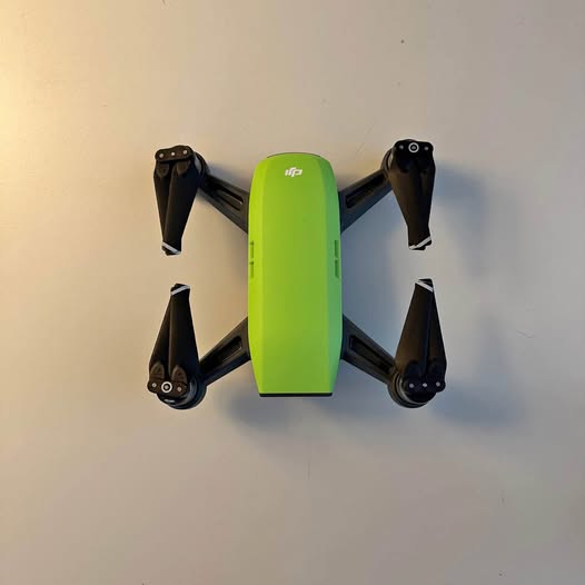 DJI Spark drone with lime green body and four black foldable propellers