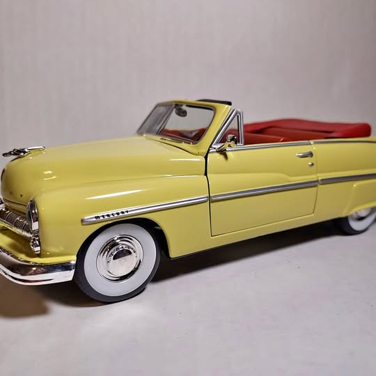 Yellow convertible diecast car with red interior, front three-quarter view
