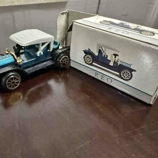 Vintage diecast model car with packaging, blue and dark gray, displayed with box end