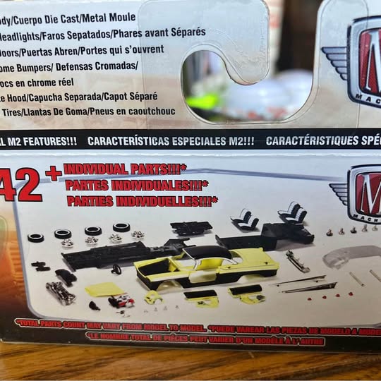 M2 Diecast project car model set with yellow car and small parts on package