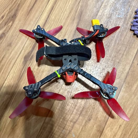 Racing drone with four red propellers and black body, visible top view