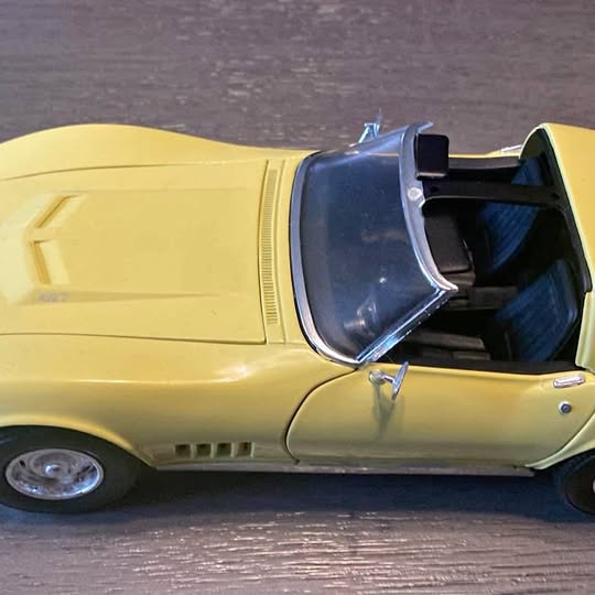 Yellow 1968 Corvette diecast car model, front side view with blue interior