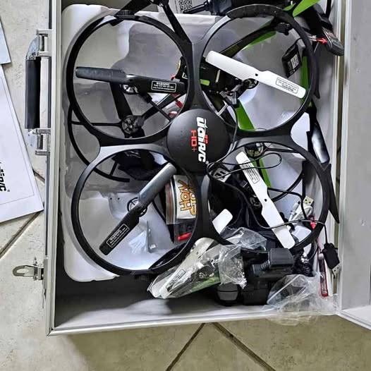 Black and white quadcopter drone with four propellers in protective packaging
