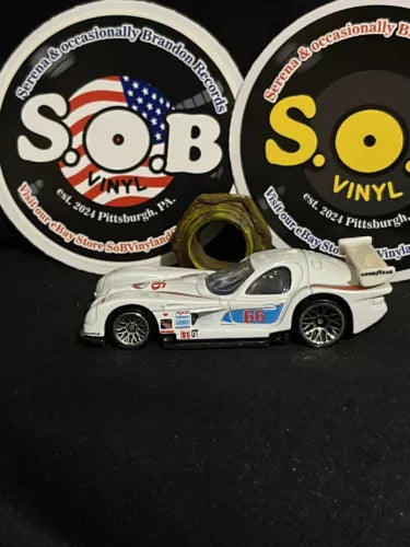 White diecast race car, side view with red and blue stripe decals