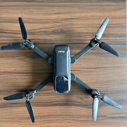 Black quadcopter drone with four propellers and foldable arms
