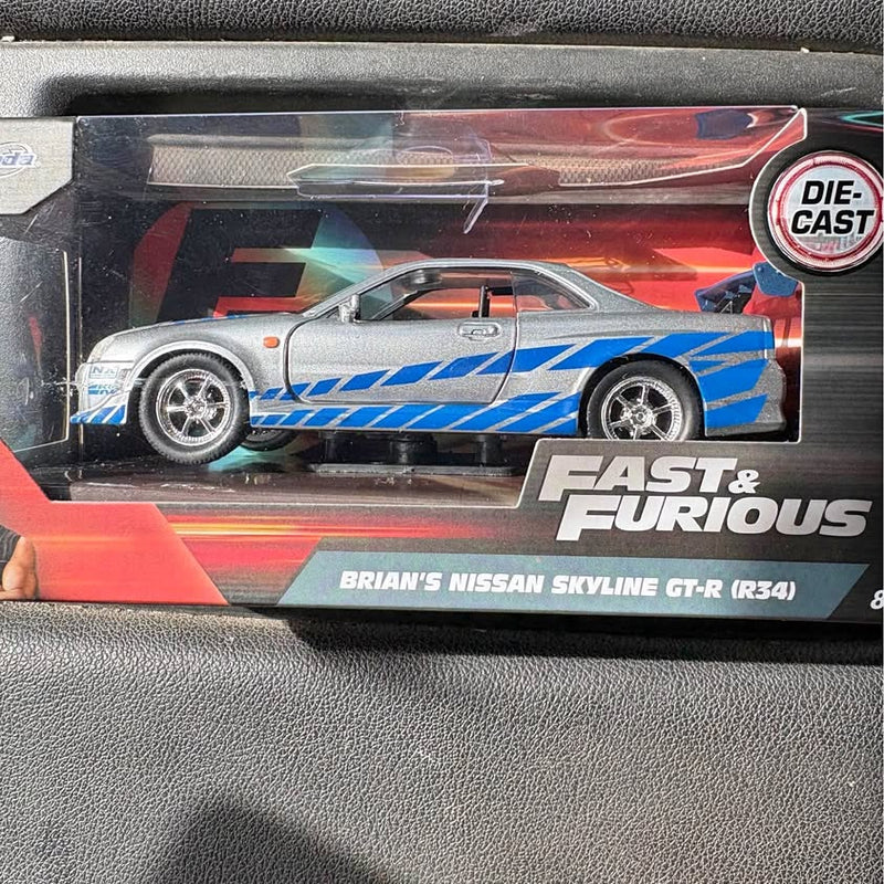 Die-cast sports car in silver with blue racing stripes and orange accents