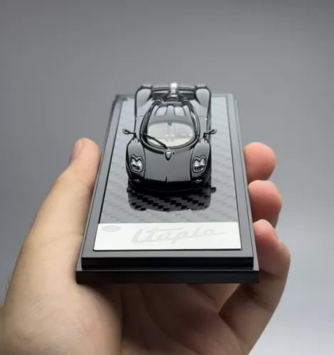 1:64 black diecast racing coupe model, front view with headlights