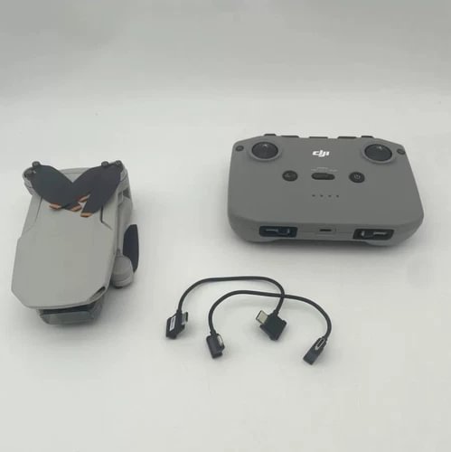 Gray remote controller with two joysticks and connected cable adapters