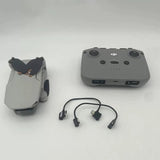 Gray remote controller with two joysticks and connected cable adapters