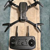 Foldable four-axis drone with quad rotors and handheld controller, dark gray