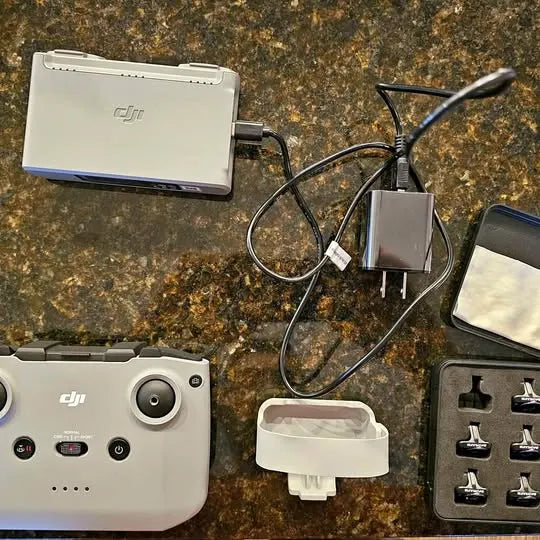 Drone controller with charging hub, cables, and spare battery accessories