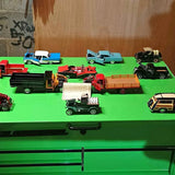 Diecast car and truck set with multiple miniature vehicles, mixed colors, on green tray