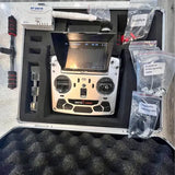 Drone controller with display and joysticks, shown in open hard case