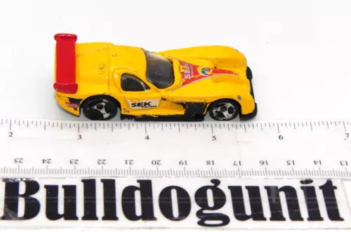 Yellow and red diecast police car toy, black wheels and cockpit window, SEK marking