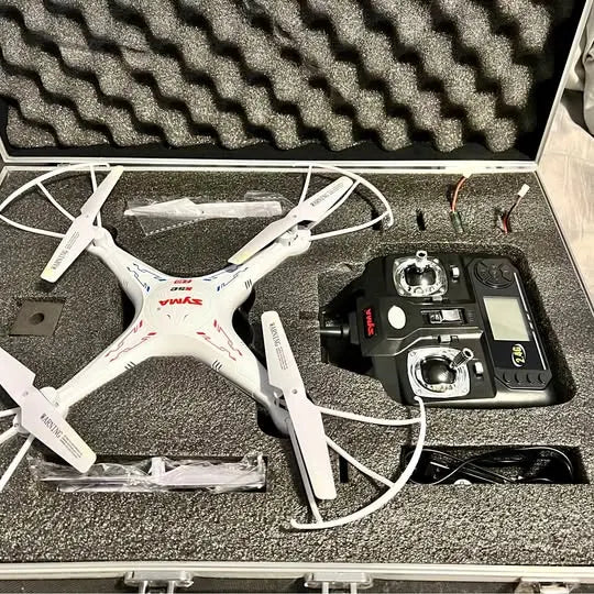 White quadcopter drone in open carrying case with remote controller