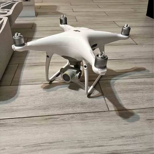 White quadcopter drone with four propeller arms