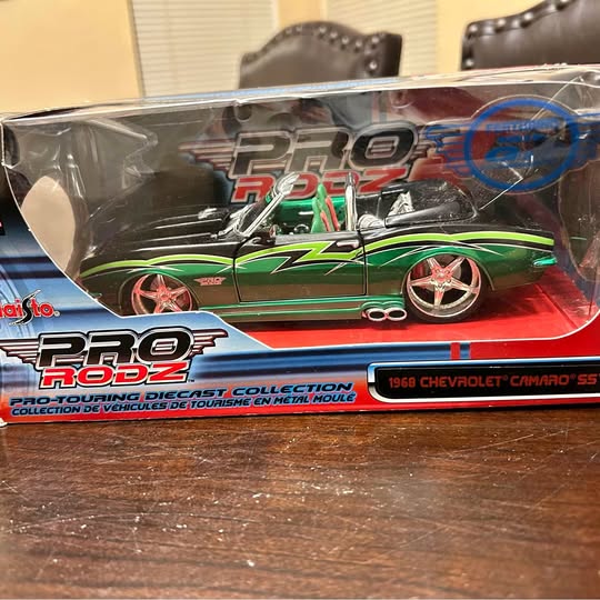 Green Camaro diecast model in retail box with clear window and chrome wheels