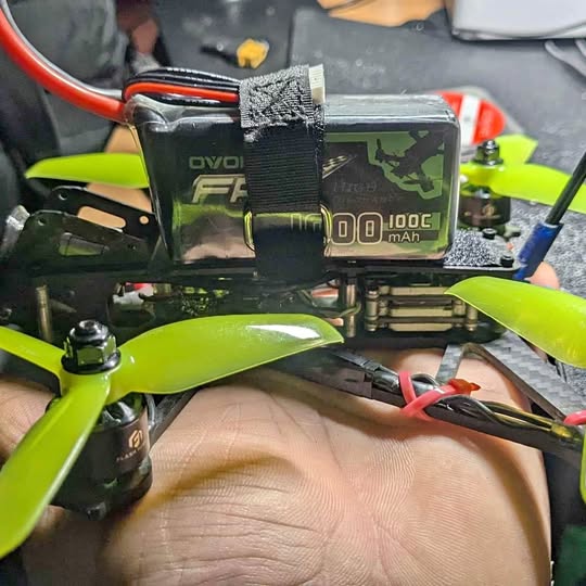 FPV drone with green propellers and battery pack