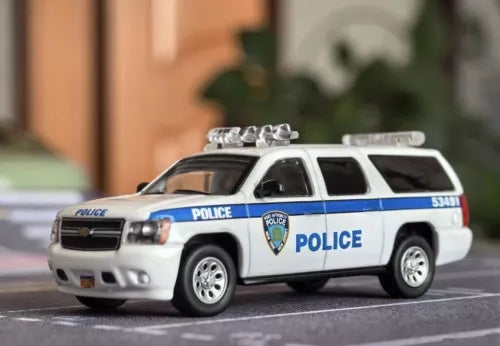 White and blue die-cast police SUV toy car with roof lights, side view