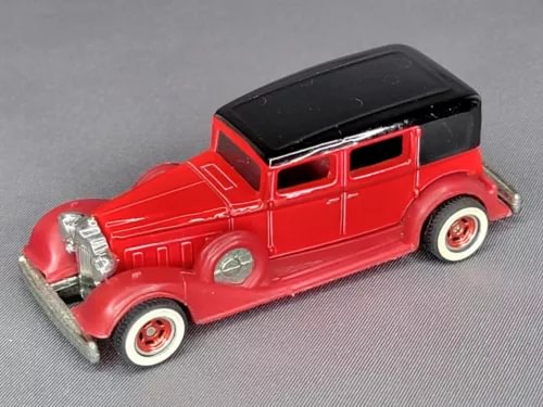 Red 1:64 diecast classic car with black roof and chrome details, red-and-white wheels