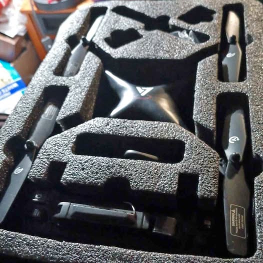 Black drone accessory kit with controller and tools in molded foam case