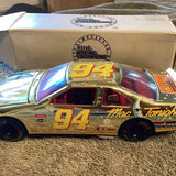 1:24 scale NASCAR diecast race car, #94, gold and multicolor chrome, red interior.