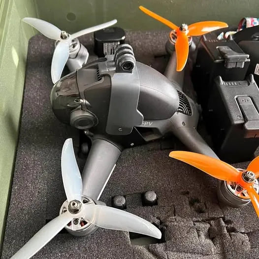 FPV drone with black body, orange propellers, and front camera module
