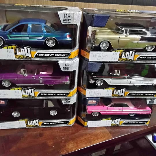 Boxed 1/24 scale lowrider diecast cars in teal, purple, tan, pink, and white