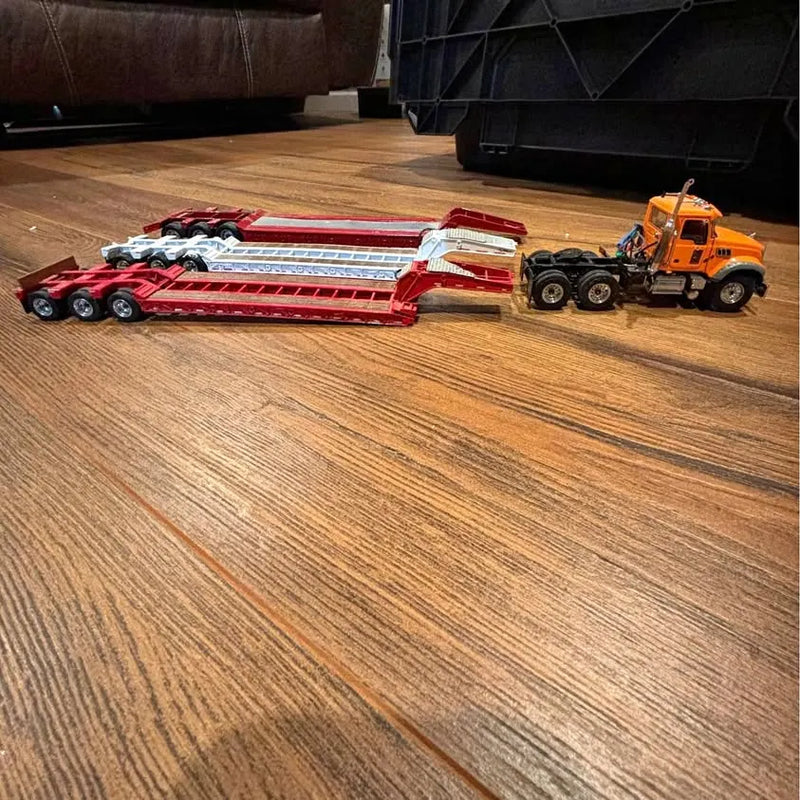 Diecast Mack tractor and lowboy trailer set with red trailer and orange tractor