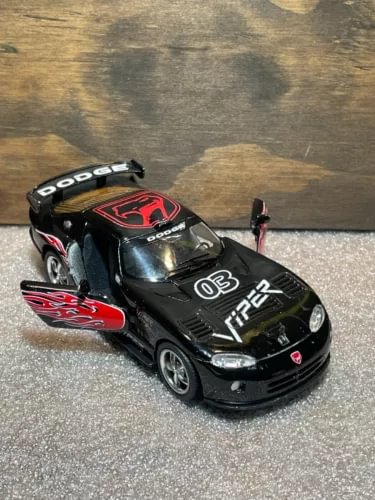 Black diecast sports car toy with red flame decals and front headlights