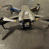 Grey quadcopter drone with front camera and propellers visible