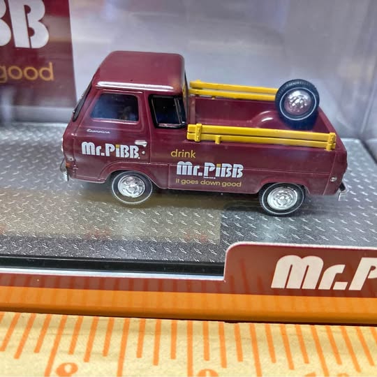 Maroon diecast toy truck with yellow front crane and round headlight