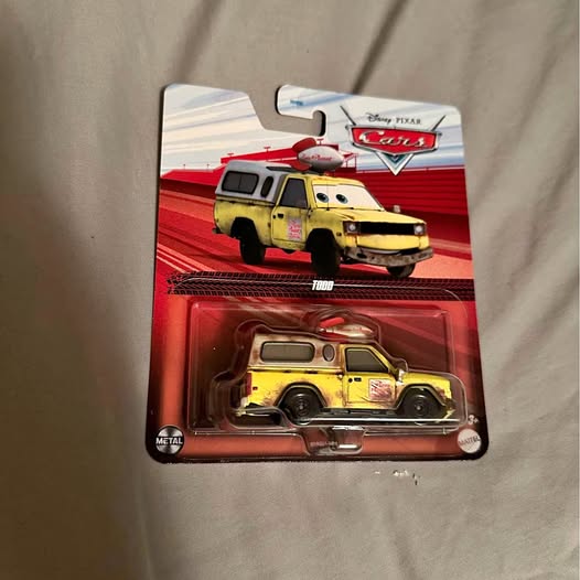 Cars diecast vehicle in red blister package, yellow tow truck with black wheels