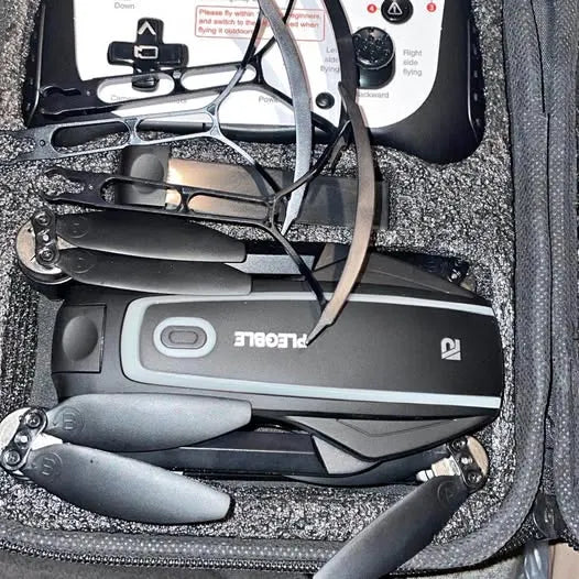 Folding gray quadcopter drone with camera, motors, and propellers in carrying case