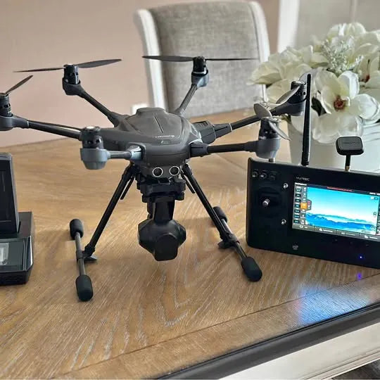 Black quadcopter drone with camera gimbal and four propellers