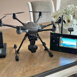 Black quadcopter drone with camera gimbal and four propellers