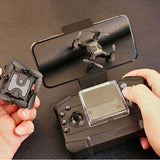 Small gray quadcopter mini drone with remote controller and propellers extended