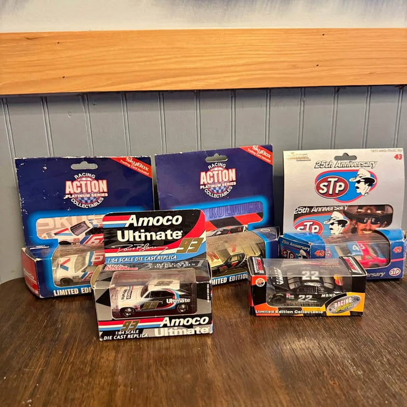 Diecast NASCAR car set in boxes, Amoco Ultimate and STP branding, racing action packaging