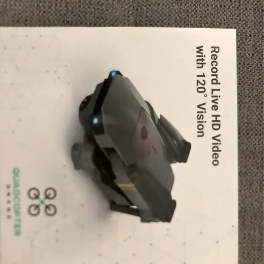Quadcopter drone in packaging, gray body with front camera and landing arms