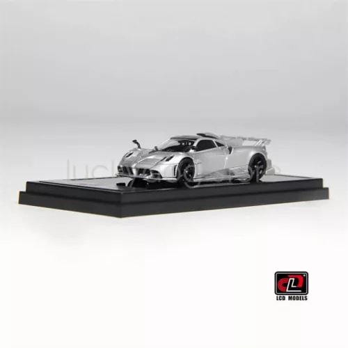 1:64 scale silver diecast sports car model with black hood, on display base